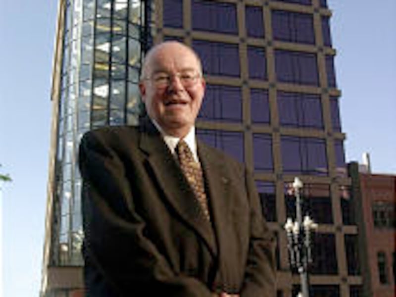 Jim Mortimer, posed in front of the building constructed during his leadership, was an icon in the U