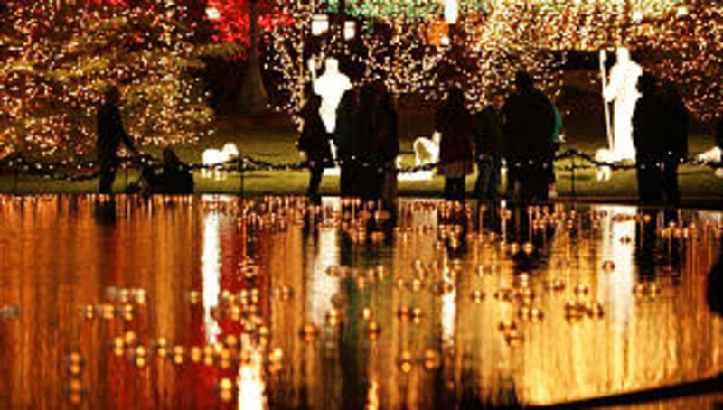 Downtown visitors walk through the Main Street Plaza as Christmas lights are turned on downtown an