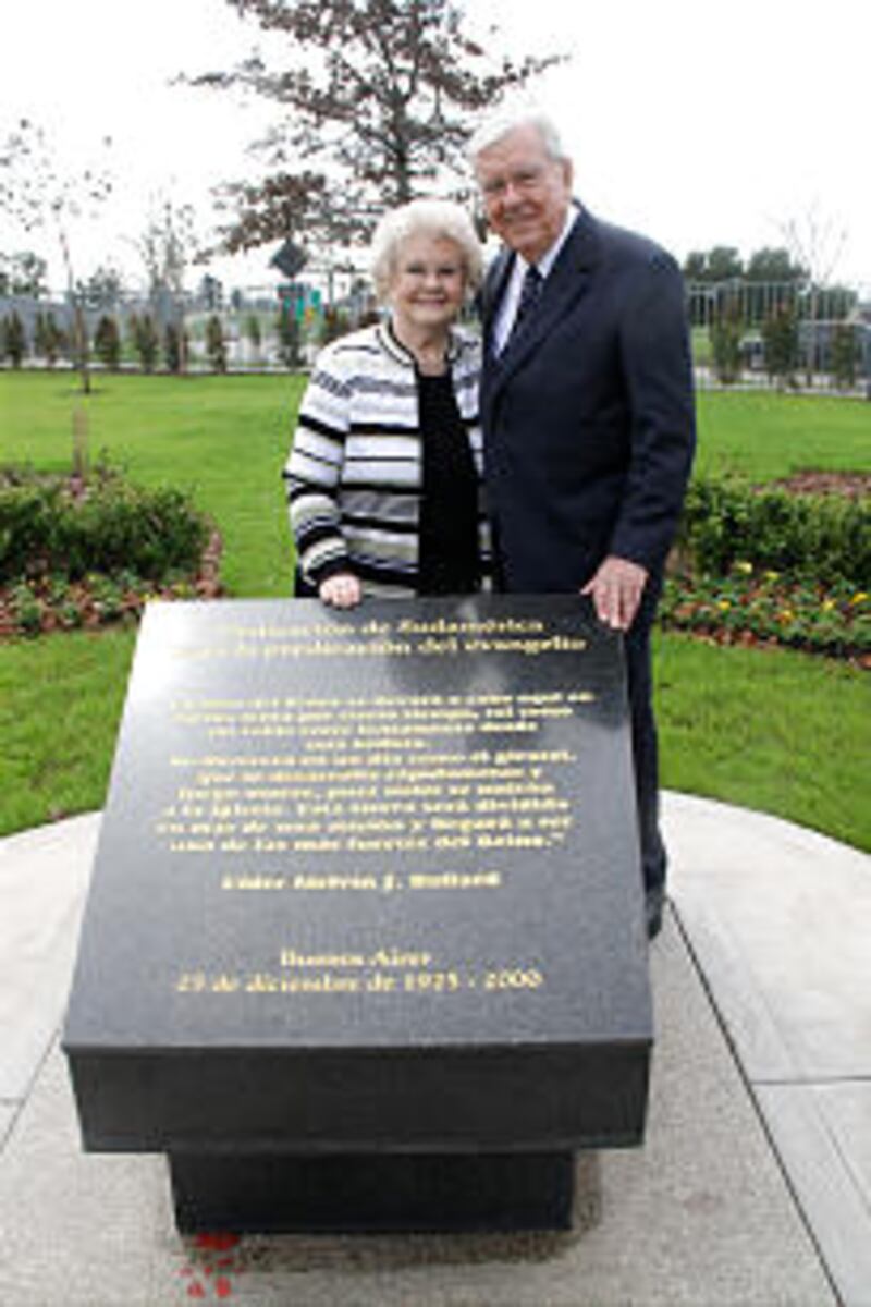 Elder M. Russell Ballard and Sister Barbara Ballard pose behind a monument near the temple commemor