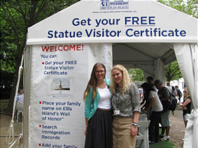 Sister Ashlyn Jorgensen, left, and Sister Holly Larson stand in front of the Family History Booth on