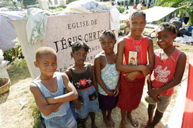Unidentified children stand near the Central Ward Church sign as they live on the grounds in Prince