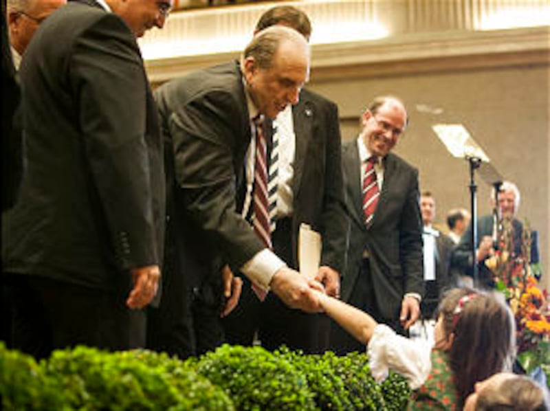 President Thomas S. Monson leans down to shake a girl's hand during his visit in Munich.