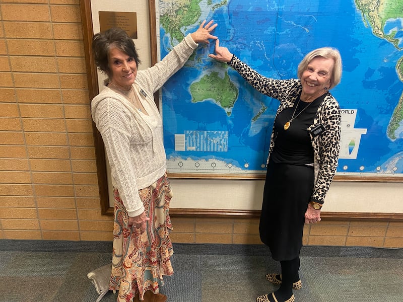 Virginia Hawkins Bryant, left, and Kathleen Moessing, right, point to their mission location on a map at the Provo Missionary Training Center.