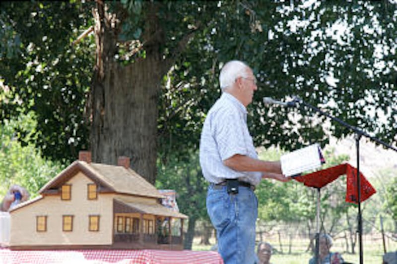 Standing next to a model of the Alonzo and Nancy Russell Home, historian Ronald L. Morris addresses