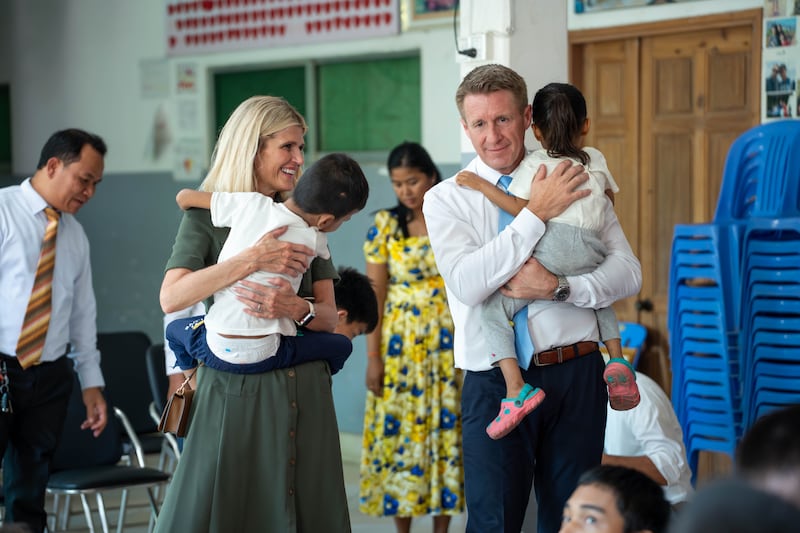Young Men General President Timothy L. Farnes, right, and his wife, Sister Linsey Farnes, hold small children while visiting the National Center for Infants and Children in Cambodia on May 23, 2026.