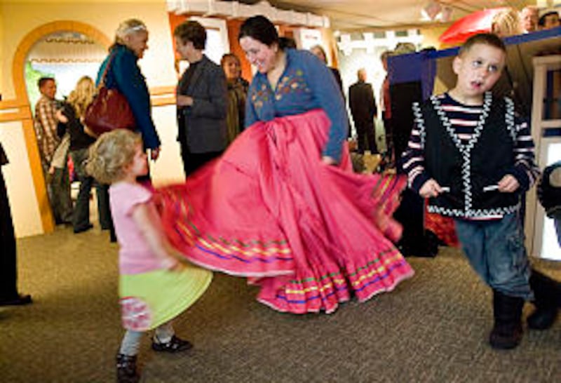 Cindy Lee performs a Mexican folk dance with her children Phebe, left, and Joseph. The interactive e