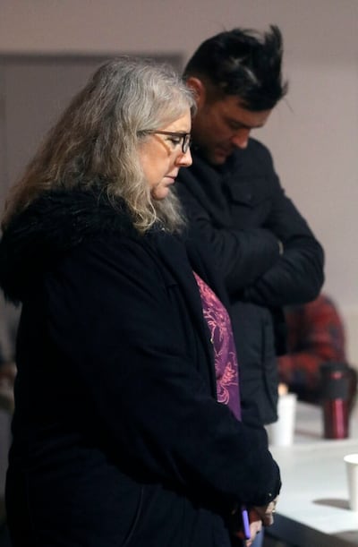 Diane Kienholz and her son Jesse Kinman bow their heads in prayer before volunteers with Freezing Nights feed the homeless at Puyallup Nazarene Church in Puyallup, Wash., on Sunday, Jan. 26, 2020. Kinman is currently homeless, but still volunteers to help other homeless have a place to sleep. Kienholz transports the homeless to a church to sleep every Sunday night.
