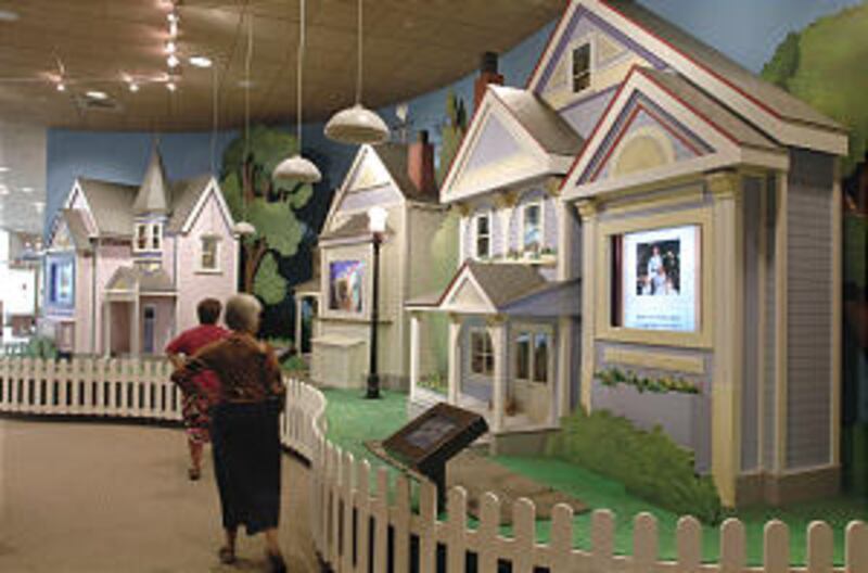 Visitors view exhibit emphasizing family.