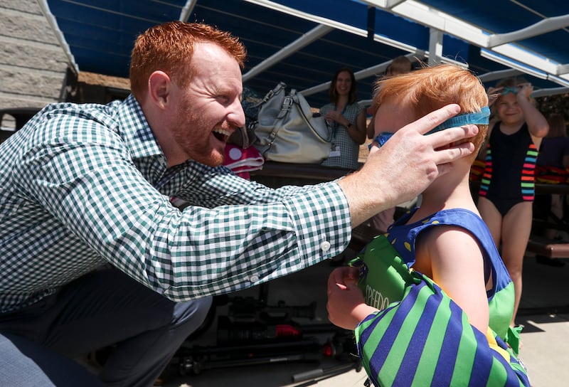 Nathan Miles, 3, gets new goggles from his dad, Todd Miles, as he gets ready to swim at the I.J. & J