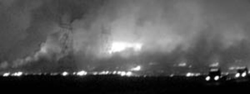 Shown in center of photo, roof of their home is seen aglow as fire consumes everything in the area.