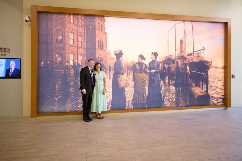 New mission leaders take a picture by the mural of the first single sister missionaries at the Provo MTC.