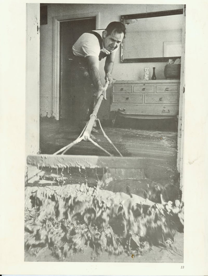 Rexburg, Idaho, resident Garrett Case sweeps mud out of his home following the rupture of the Teton Dam in June 1976.