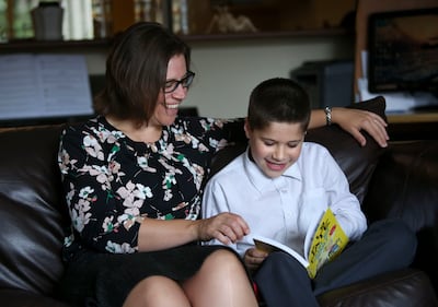 Jenny Friesen listens as her son Luke Friesen reads at home in Langley, British Columbia, on Sunday, Sept. 16, 2018.