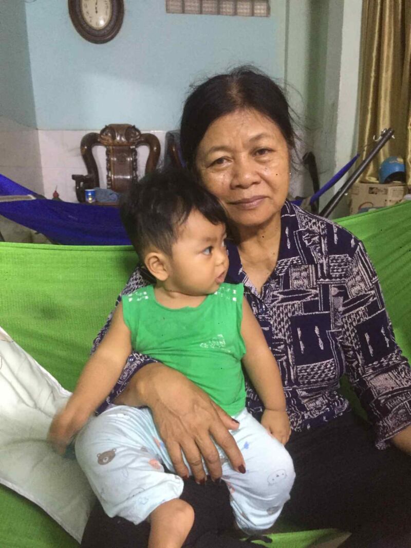 Chan Sovan snaps a photo with her 12th grandchild in Phnom Penh, Cambodia.