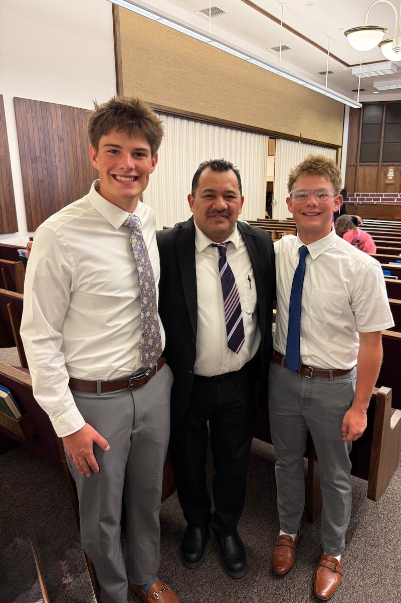 Twin brothers Eli and Isaac Reid pose for a picture with Bishop Julian Murillo.