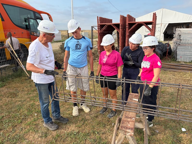 Elder John Dickson, a full-time humanitarian missionary for The Church of Jesus Christ of Latter-day Saints, works with young adults preparing reinforced steel during a Habitat for Humanity Romania service project in Berceni, Romania, in August 2026.