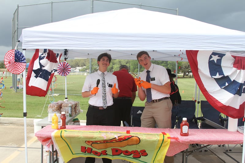 Missionaries pose in front of the hot dog stand at "Fiesta 2026" in San Antonio, Texas, on April 11, 2026. Missionaries assisted in parking, serving food and welcoming guest to the event.