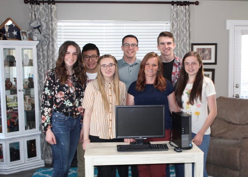 Cindy Cloninger, whose husband died in February 2012, stands with her six children and a computer and printer donated by the Stella Oaks Foundation in April 2020.
