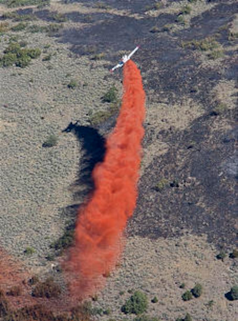 A Single Engine Air Tanker (SEAT) drops a fire retardant mixture over Herriman wildfire two days aft