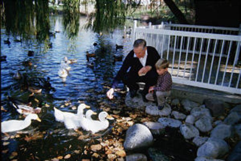 In 1985, he spends time with grandson Matthew Smith in feeding ducks.