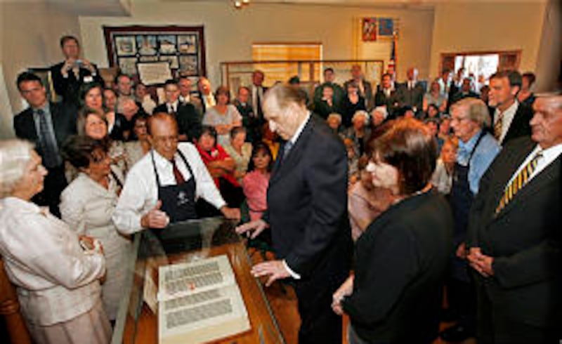 Louis Crandall of the Crandall Historical Printing Museum, center, shows President Thomas S. Monson