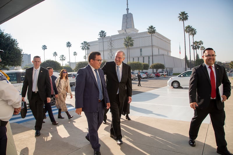 With the Mexico City Mexico Temple in the background, Elder Neil L. Andersen of the Quorum of the Twelve Apostles talks with a member while walking to a meeting in Mexico City, Mexico, on Nov. 22, 2025.