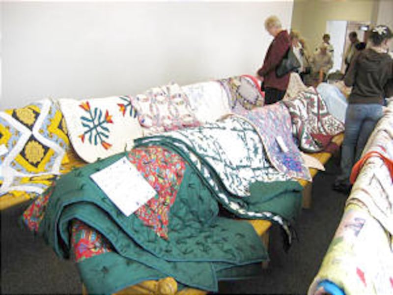 Quilt display at tabernacle celebration. Quilts are made for humanitarian center.