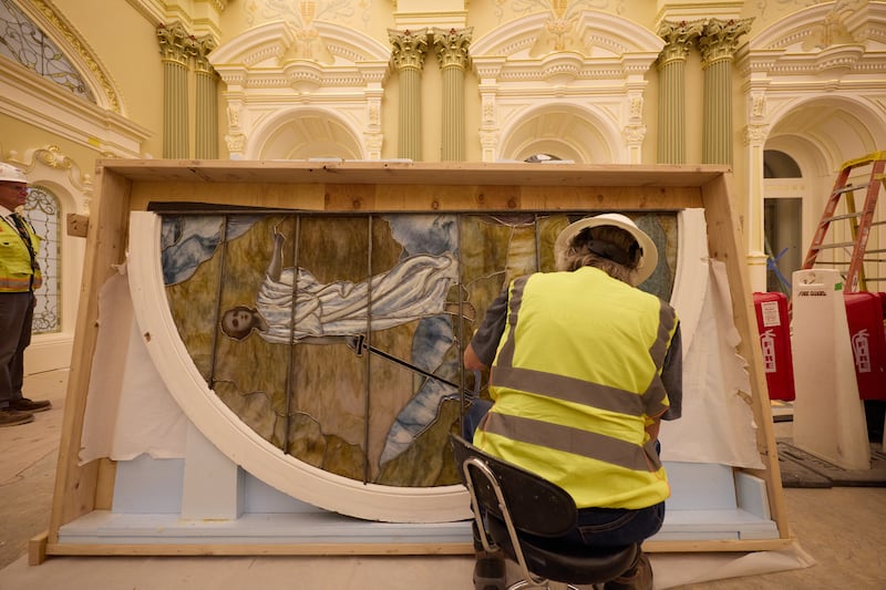 A worker cleans an art-glass piece featuring Adam and Eve during installation on Tuesday, April 21, 2026, in Salt Lake City. The artwork will be in the celestial room of the Salt Lake Temple.