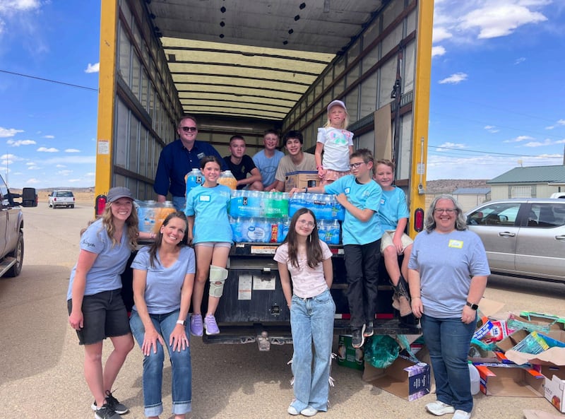 Children, youth and adults in Albuquerque, New Mexico smile with a truck load of donated water to help the water shortage in the community of To’hajilee on May, 6, 2026.