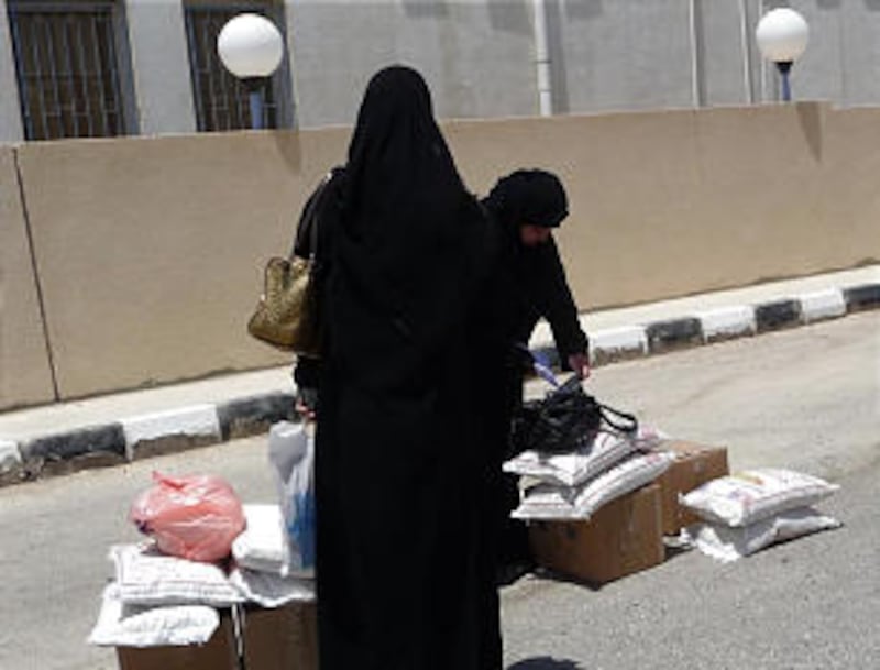 Syrian women receive food donated by LDS Charities in Jordan, where many refugees have crossed the b