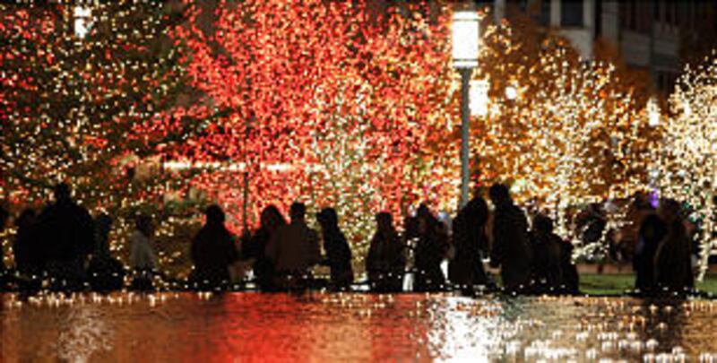 Downtown visitors walk through the Main Street Plaza as Christmas lights are turned on downtown an