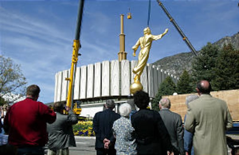 A crowd gathered at the Provo LDS Temple to watch an Angel Moroni statue being lifted up by a crane