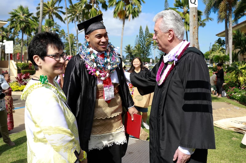Elder Dieter F. Uchtdorf of the Quorum of the Twelve Apostles stands with his wife, Sister Harriet Uchtdorf, and a BYU-Hawaii graduate after commencement exercises on Dec. 14.