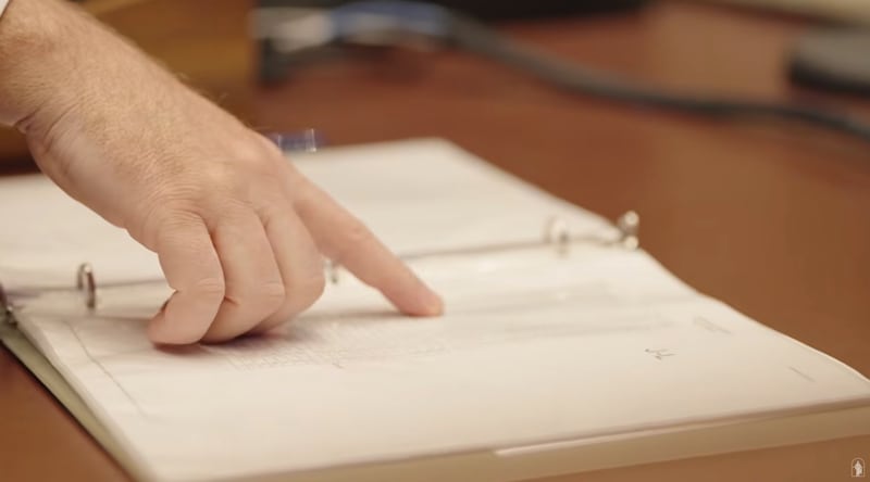 Aaron Kobel, an audio engineer for the Church, looks at a book that tracks the pulpit height for each speaker at general conference.
