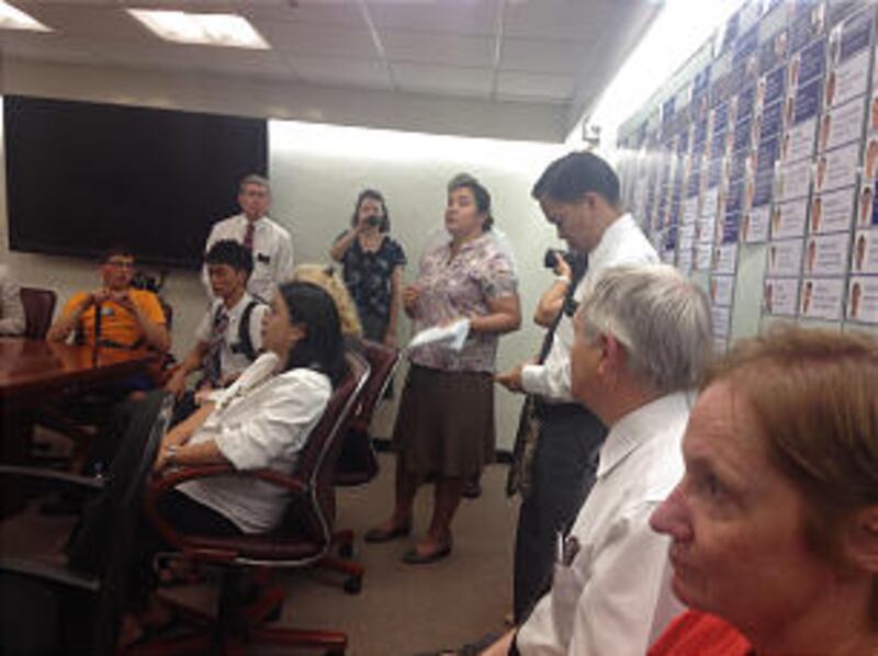 Elder Kyle Marlin of Star, Idaho, orange shirt, and Elder Norman Disbarro, sitting at Marlin's left,