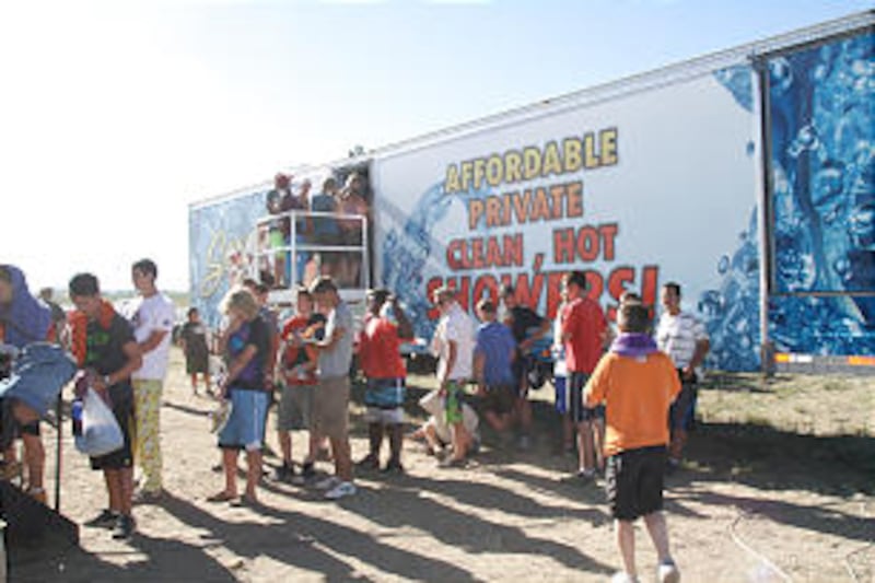 Scouts wait in line to shower in a portable facility at the 2013 Rise Up Scout Camp in southeastern