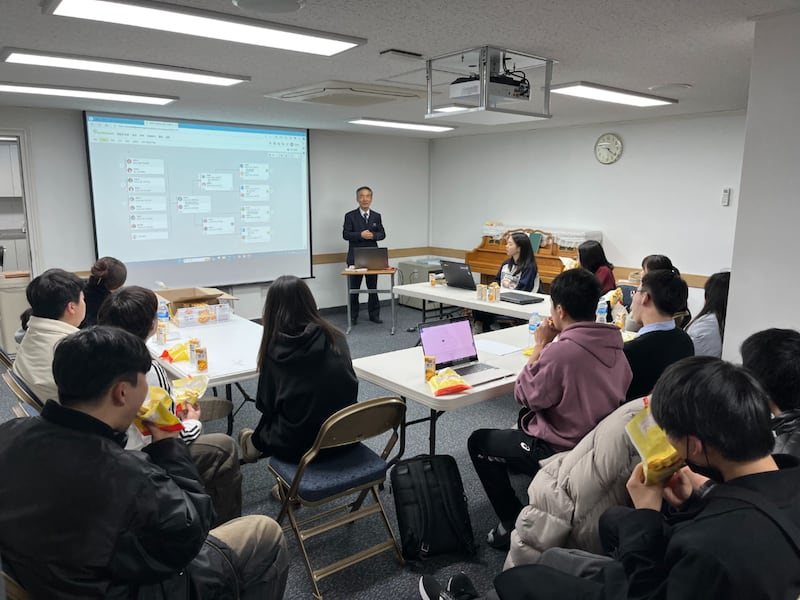 A senior missionary in Korea teaches a family history class.