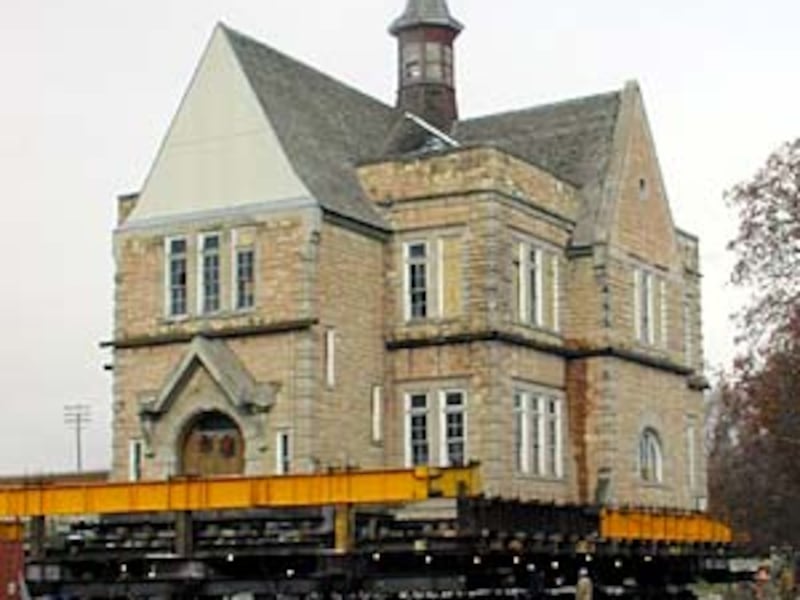 The Oneida Stake Academy building rolls on 41 hydraulic dollies down a street in Preston, Idaho, to