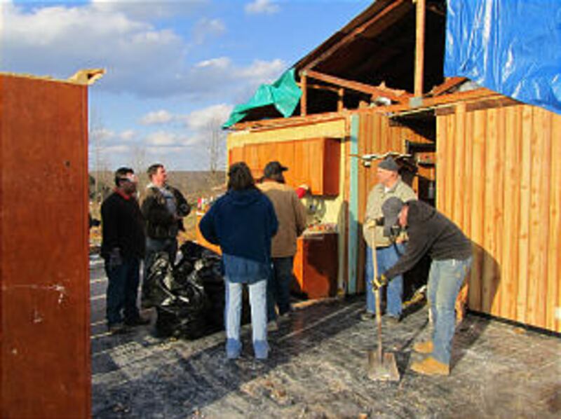 New Albany Indiana Stake members clear debris from what remains of a house following tornadoes in th