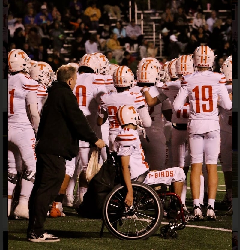 Father Ken Cooper pushes his son, Matthew Cooper, in his wheelchair on the sidelines during a Timpview High School football game in Provo, Utah, in the fall of 2024.