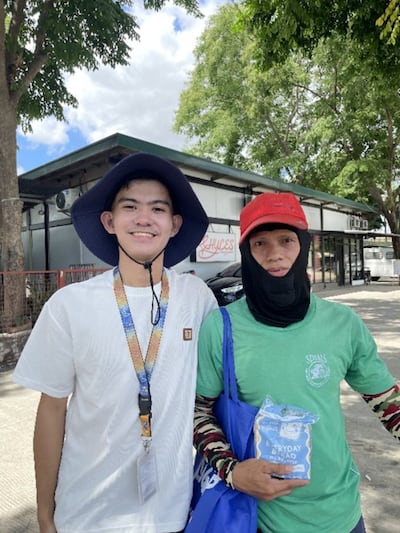 Rodolfo Gallinero III, left, poses for a photo with the recipient of a care kit assembled by young students in Santo Tomas, Philippines, on May 1, 2026.