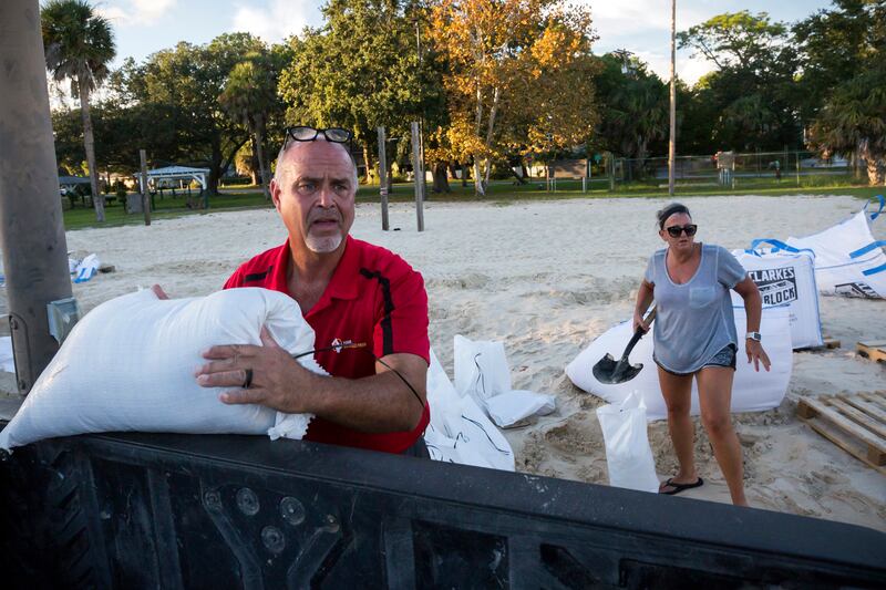 Tybee Island residents Sib McLellan, left, and his wife, Lisa McLellan, load sandbags into the back of their truck while preparing for Hurricane Florence, Wednesday, Sept., 12, 2018, on Tybee Island, Ga.