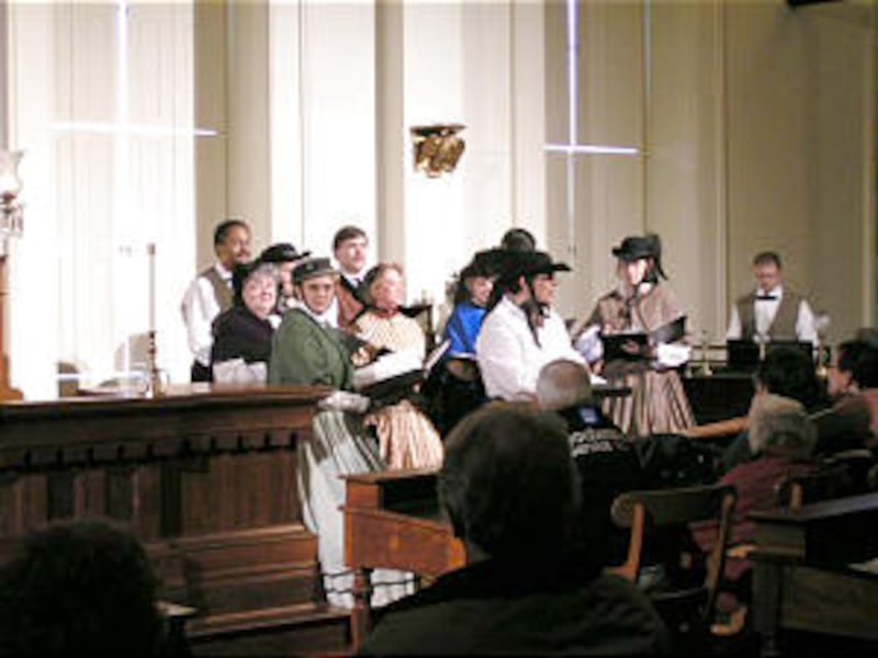 Guides in 19th century attire prepare to lead candlelight tours.