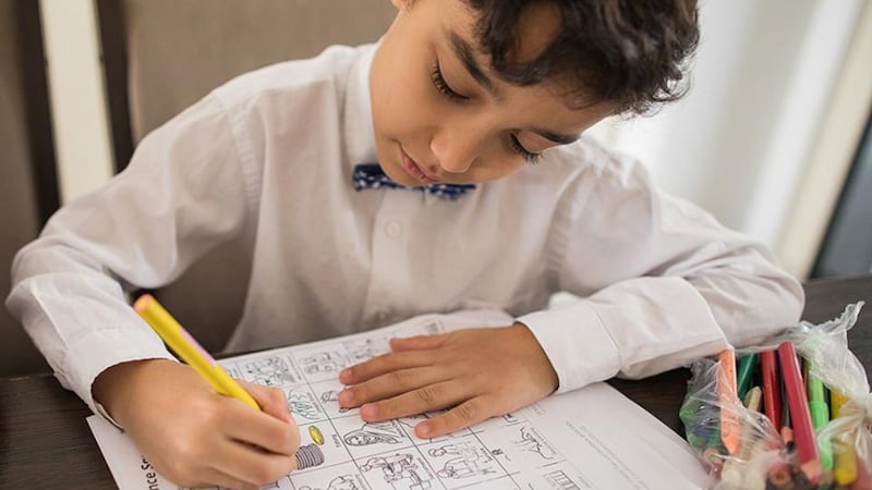 A young boy plays Conference Squares, a hands-on listening game with spaces children can color in.