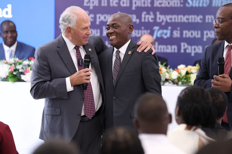 Elder Ronald A. Rasband of the Quorum of the Twelve Apostles, left, puts his arm around a Latter-day Saint leader during a priesthood meeting in the border city of Dajabón, Dominican Republic, during a visit to the city on Sept. 11, 2026.