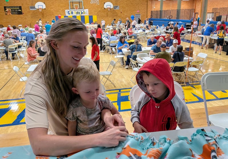 Tawnya Turner shows her children how to tie a fleece blanket as part of a National Day of Service and Remembrance event in Centerville, Utah, on Saturday, Sept. 12, 2026.
