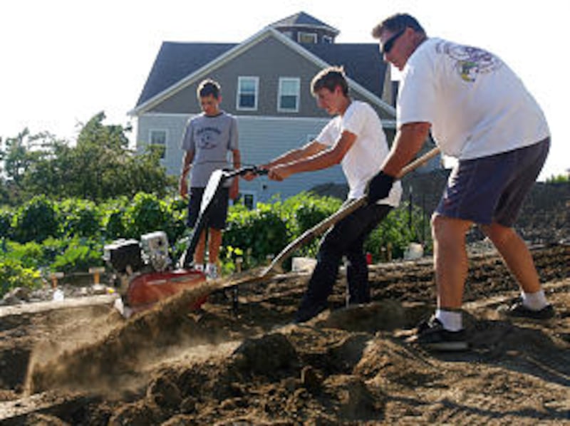 Austin Wright, Golden Bishop and Justin Willard, left to right, join other ward members in the garde