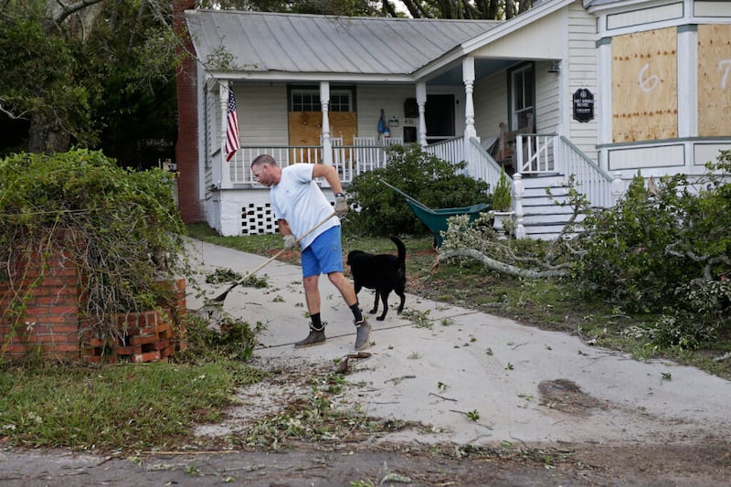 Resident Frank Spencer cleans up following the effects of Hurricane Isaias in Southport, N.C., Tuesday, Aug. 4, 2020. (AP Photo/Gerry Broome)