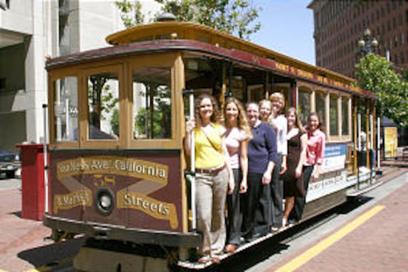 Young single adult women who are members of the Church hop on a cable car in downtown San Francisco
