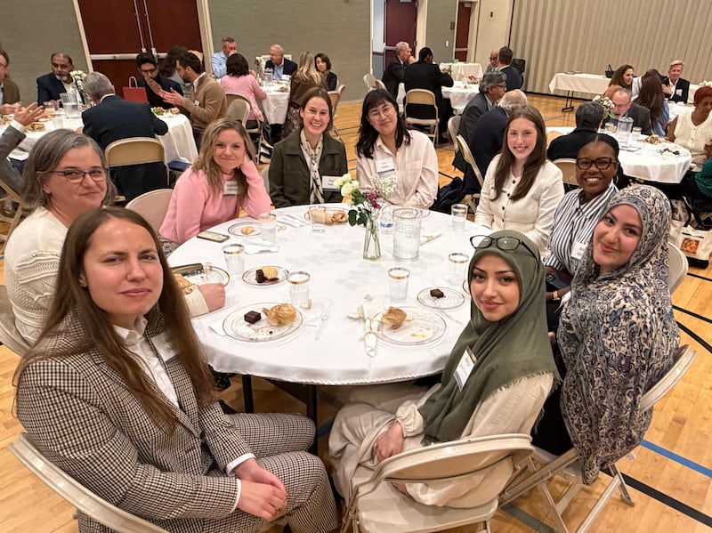 Women sit at a table to eat a meal together at an interfaith gathering in Chicago, Illinois, on Oct. 14, 2026.